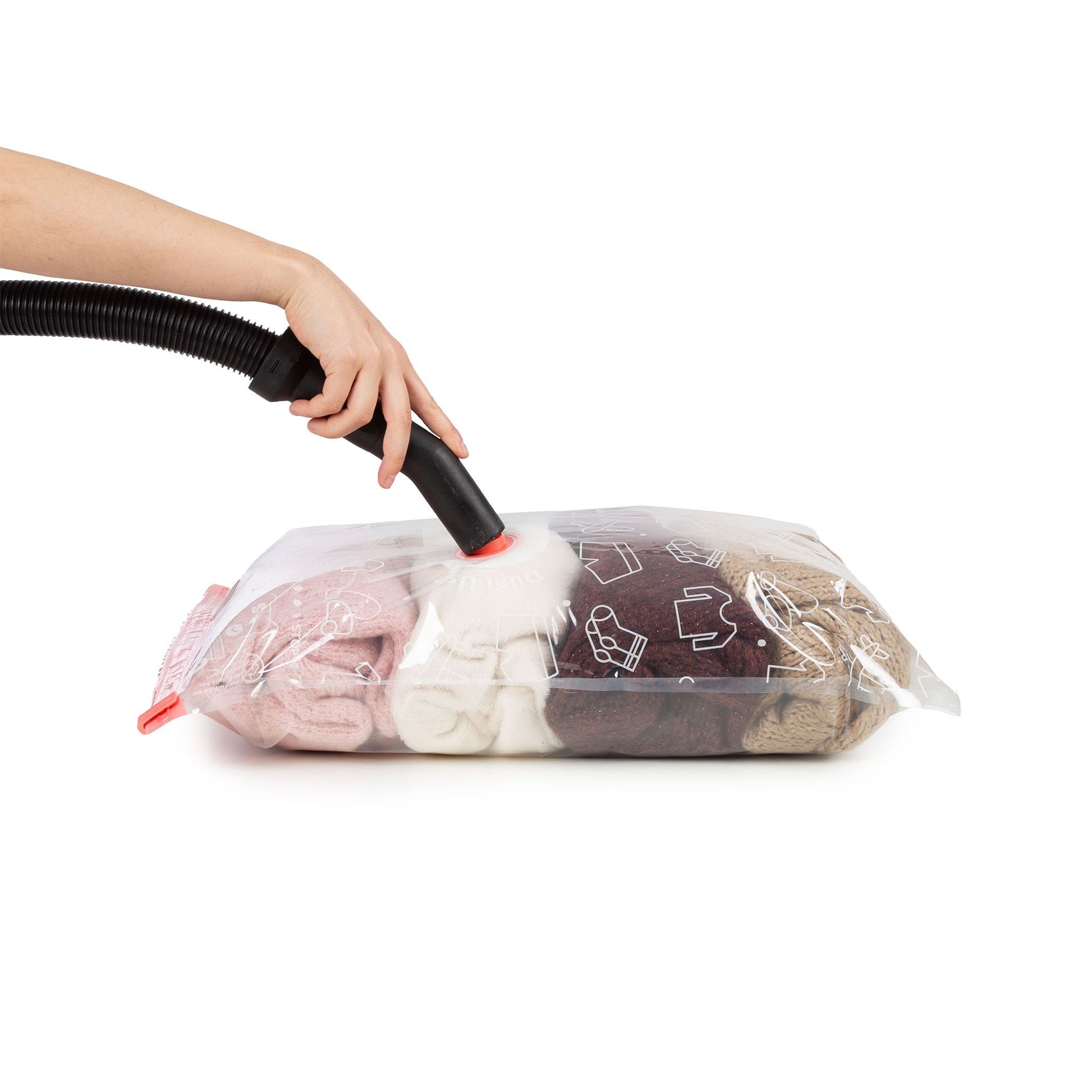 Sac de rangement sous vide avec vêtements, utilisant un tuyau pour le vide, démontrant l'utilisation de sacs de rangement sous vide.